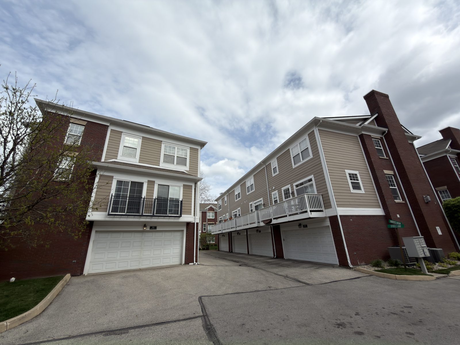 Monon and Main townhome driveway showing two buildings facing each other with restored exterior trim — Carmel, IN