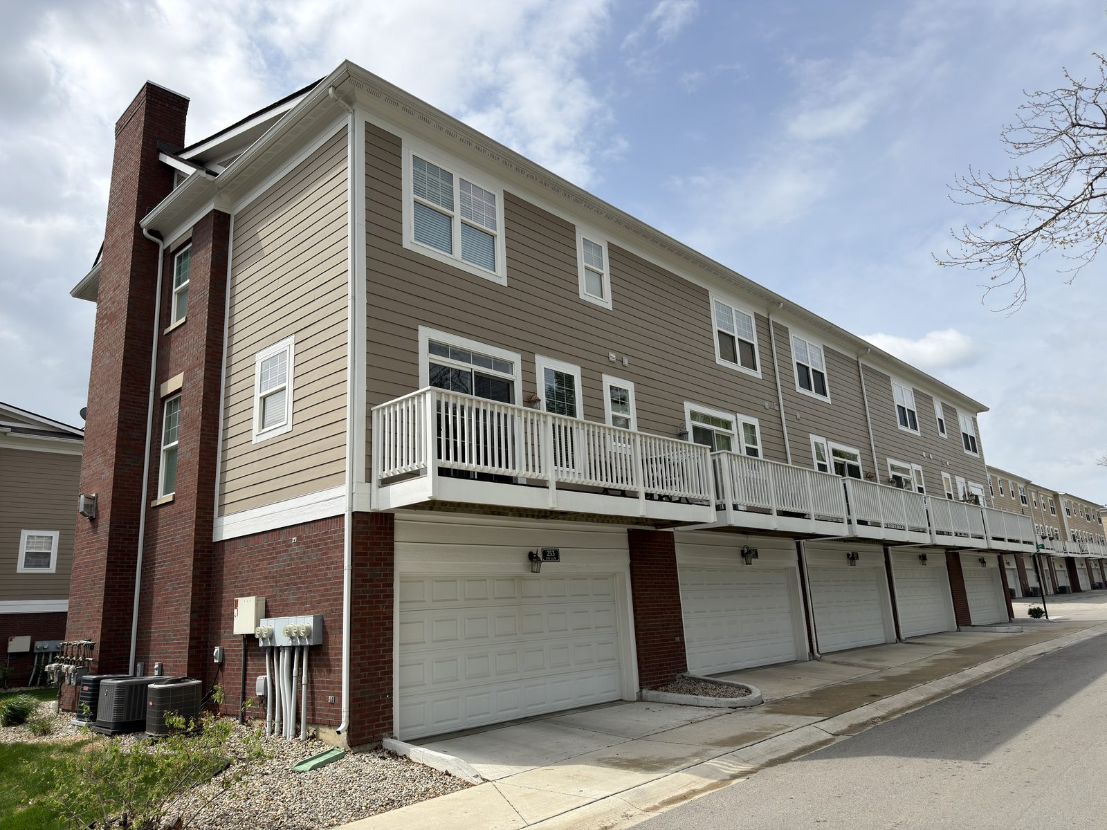 Monon and Main townhome side view — garage row, balconies, and freshly repainted trim at 428 Neuman Way, Carmel IN